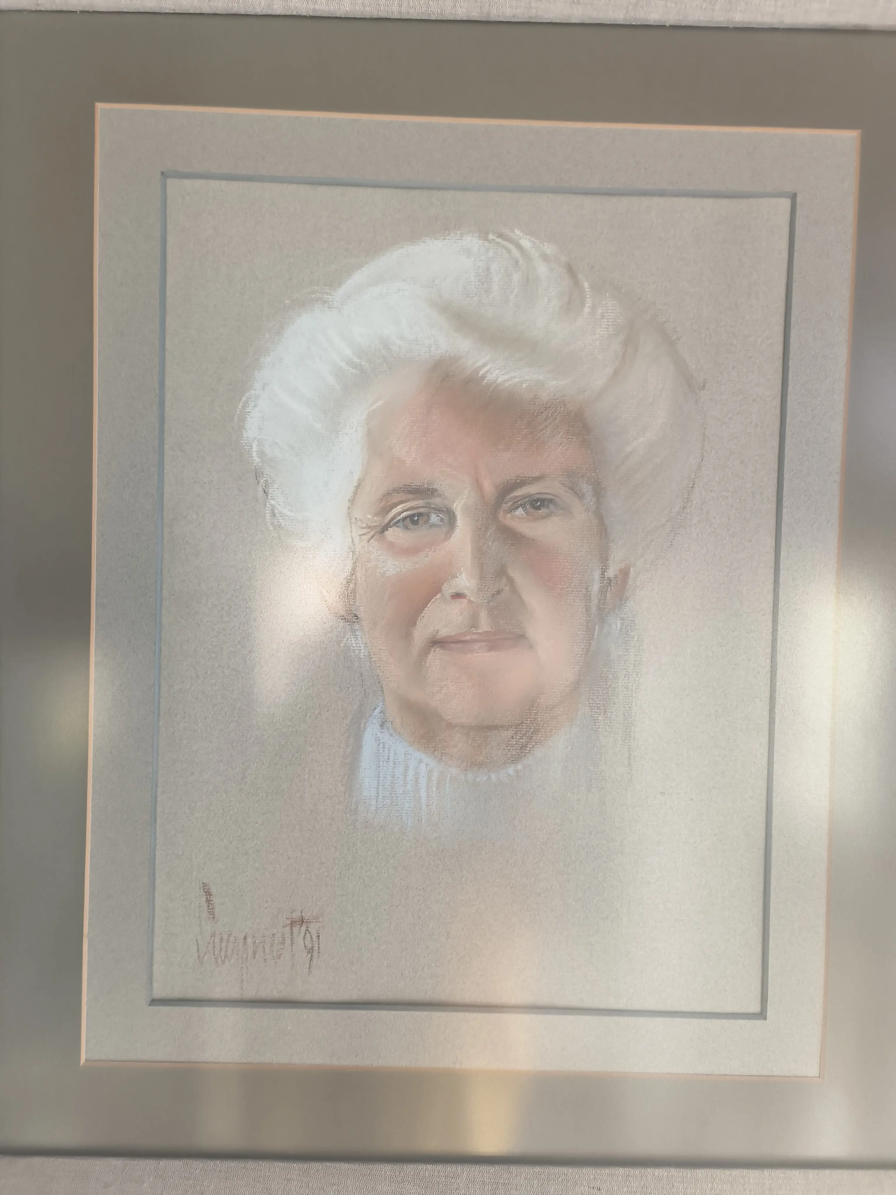A portrait of an older woman with white hair, wearing a light blue turtleneck, enclosed in a simple frame with a signature in the corner.